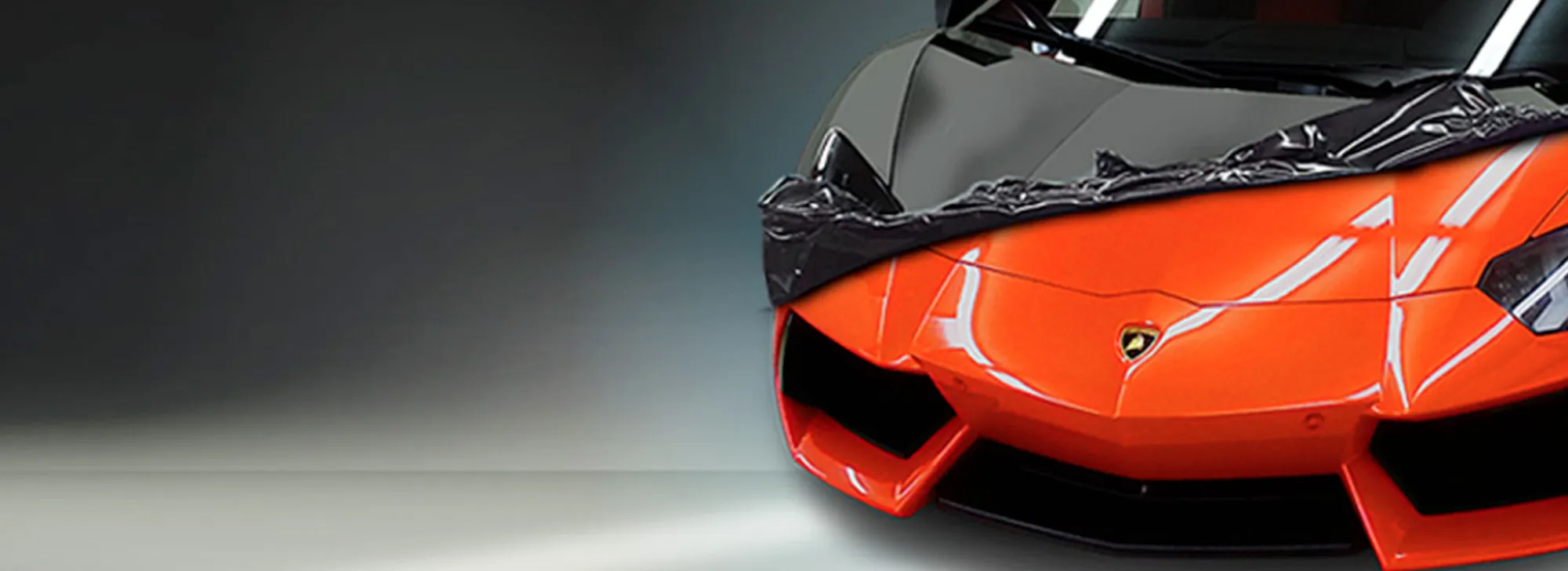 Lamborghini arancione durante il rivestimento con pellicola nera